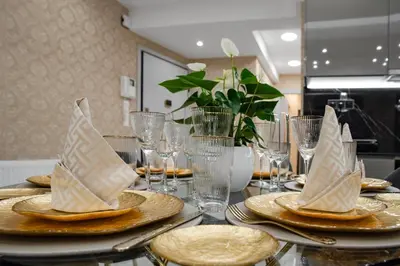 a table with plates and napkins with paper boats on it at Crystal Parthenon - Luxury Design Apartment near Acropolis in Athens