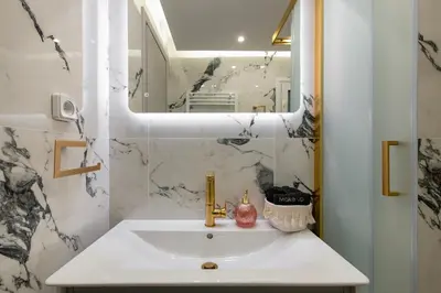 a white bathroom with a sink and a mirror at Crystal Parthenon - Luxury Design Apartment near Acropolis in Athens