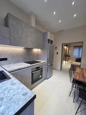 a kitchen with stainless steel appliances and a table at 3siblings A1 in Athens