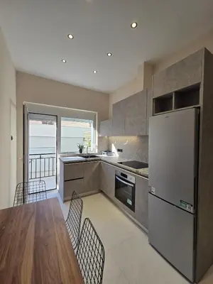 a kitchen with a wooden table and a refrigerator at 3siblings A1 in Athens