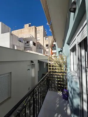 a balcony with a man standing on top of a building at 3siblings A1 in Athens