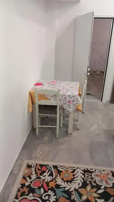 a table and chair with a table and a rug at House Marios airport 3 in Spáta