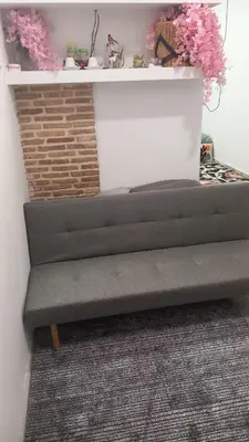 a gray bench in a room with pink flowers at House Marios airport 3 in Spáta