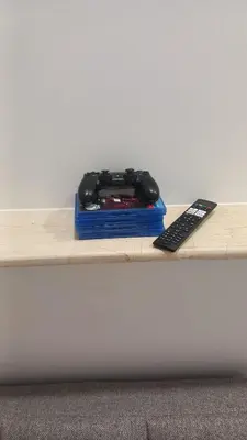a video game controller and a remote control on a table at House Marios airport 3 in Spáta