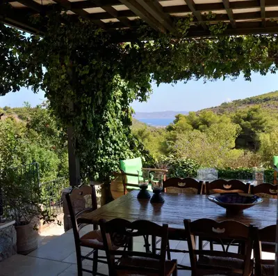 a table and chairs on a patio with a view at Villa Pepy in Áyios Konstandínos
