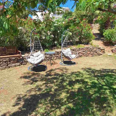 two iron chairs and a table in a yard at Villa Pepy in Áyios Konstandínos
