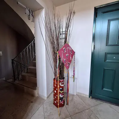 a vase with an umbrella sitting next to a door at Villa Pepy in Áyios Konstandínos