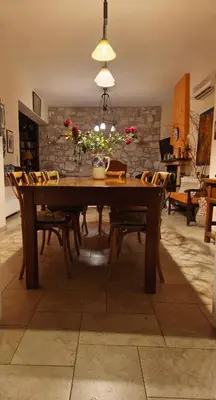 a dining room with a wooden table and chairs at Villa Pepy in Áyios Konstandínos