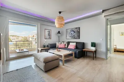 a living room with a couch and a table at South Blue Beach & Park Apartment in Vouliagmeni in Athens