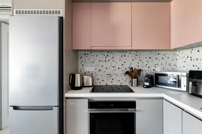 a kitchen with white appliances and pink cabinets at South Blue Beach & Park Apartment in Vouliagmeni in Athens