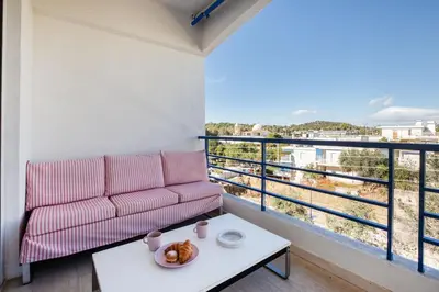 a living room with a couch and a table at South Blue Beach & Park Apartment in Vouliagmeni in Athens