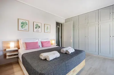a bedroom with a bed with towels on it at South Blue Beach & Park Apartment in Vouliagmeni in Athens