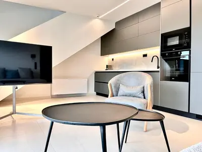 a living room with a table and a chair and a kitchen at 2BR Sea View Loft with private Jacuzzi in Riviera in Athens