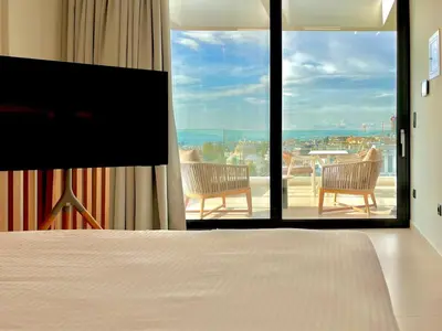 a bedroom with a bed and a view of a balcony at 2BR Sea View Loft with private Jacuzzi in Riviera in Athens