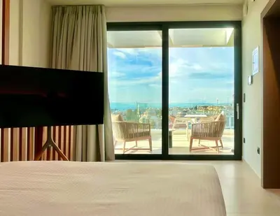 a bedroom with a bed and a view of a balcony at 2BR Sea View Loft with private Jacuzzi in Riviera in Athens