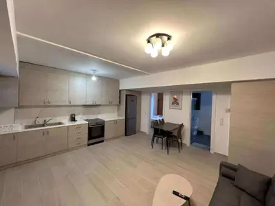 a kitchen and living room with a table and a couch at Seaside Comfort Stay apartment in Athens