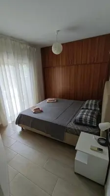 a bedroom with a bed with a wooden headboard at Seaside Comfort Stay apartment in Athens