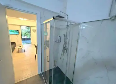 a bathroom with a shower with a glass enclosure at Seaside Comfort Stay apartment in Athens
