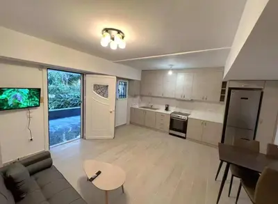 a kitchen with a couch and a table in a room at Seaside Comfort Stay apartment in Athens