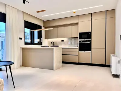 a kitchen with beige and black cabinets and a table at Athenian Riviera Hideaway, 1 BR in Glyfada in Athens
