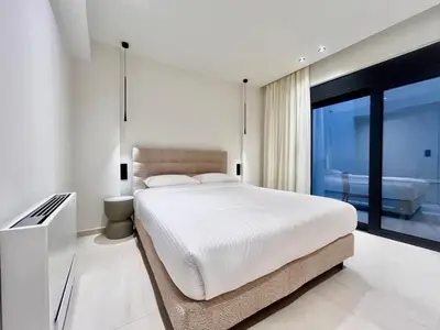 a white bedroom with a bed and a large window at Athenian Riviera Hideaway, 1 BR in Glyfada in Athens