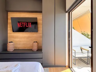 a bedroom with a netflix sign on the wall at Top Floor Elegant Escape in Glyfada Center in Athens