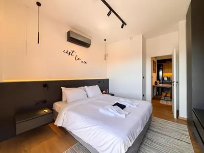 a bedroom with a bed with white sheets and a sign on the wall at Top Floor Elegant Escape in Glyfada Center in Athens