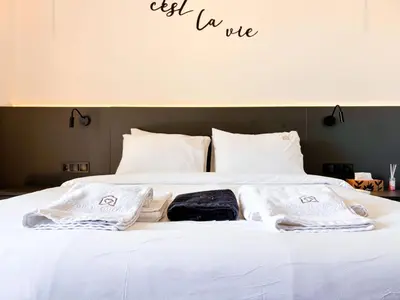 a bed with white sheets and towels on it at Top Floor Elegant Escape in Glyfada Center in Athens