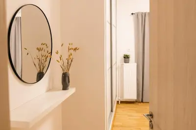 a bathroom with a mirror and a vase on a shelf at Vote Athens Apartment in Athens