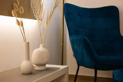 a living room with two vases and a blue chair at Vote Athens Apartment in Athens