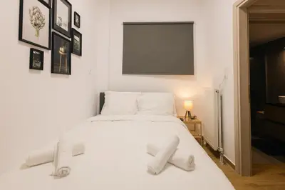 a bedroom with a white bed with white sheets at Vote Athens Apartment in Athens