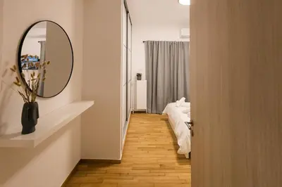 a hallway with a mirror and a bed in a room at Vote Athens Apartment in Athens