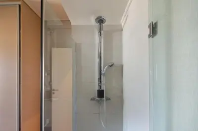 a shower with a shower head in a bathroom at Elegant 2BR Apartment near Metro, Sunny & Spacious in Athens