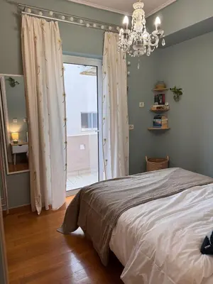a bedroom with a bed and a window with a chandelier at Elegant 2BR Apartment near Metro, Sunny & Spacious in Athens