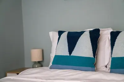 a bed with two blue and white pillows on it at Elegant 2BR Apartment near Metro, Sunny & Spacious in Athens