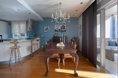 a dining room with a wooden table and a kitchen at Elegant 2BR Apartment near Metro, Sunny & Spacious in Athens