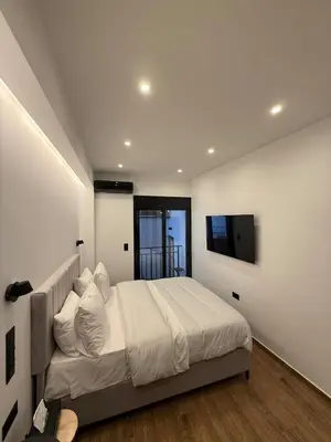 a bedroom with a bed and a tv on the wall at City Center Jacuzzi Lux 2master BD apartment in Athens