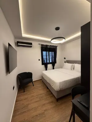 a bedroom with a bed and a desk and a computer at City Center Jacuzzi Lux 2master BD apartment in Athens
