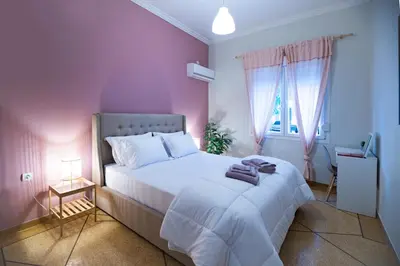 a bedroom with a large white bed with pink walls at 2 KING beds, 81 sqm, Downtown near Metro in Athens