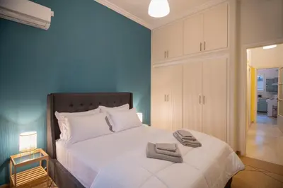 a bedroom with a large white bed with towels on it at 2 KING beds, 81 sqm, Downtown near Metro in Athens