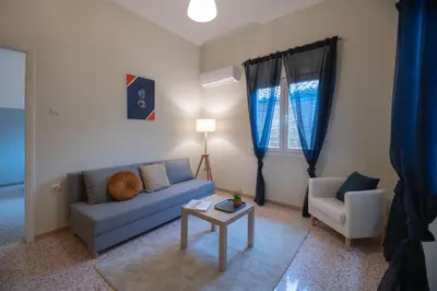 a living room with a blue couch and a table at 2 KING beds, 81 sqm, Downtown near Metro in Athens