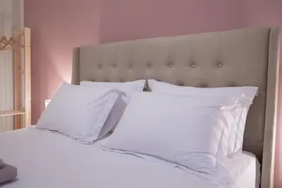 a bedroom with a white bed with white pillows at 2 KING beds, 81 sqm, Downtown near Metro in Athens