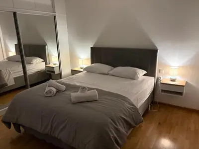 a bedroom with a large bed with towels on it at Pireaus Center Apartment in Piraeus