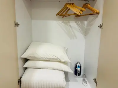 a stack of pillows in a room with a shelf at Brown Port 2 bedroom 2wc flat in Piraeus