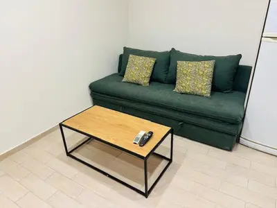 a green couch with a coffee table in a living room at Brown Port 2 bedroom 2wc flat in Piraeus