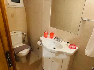 a bathroom with a sink and a toilet and a mirror at Brown Port 2 bedroom 2wc flat in Piraeus