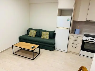 a living room with a green couch and a coffee table at Brown Port 2 bedroom 2wc flat in Piraeus