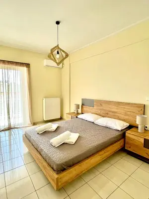 a bedroom with a large bed with two towels on it at Sky View Athens Airport Apartment in Spáta