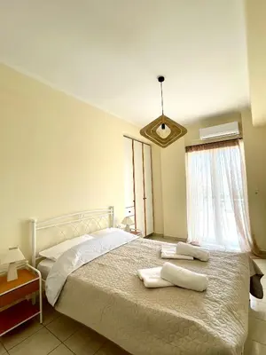 a bedroom with a bed with two towels on it at Sky View Athens Airport Apartment in Spáta