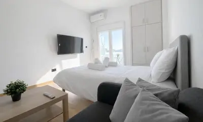 a bedroom with a large bed and a couch at Athens View Studio Near Lycabettus Hill by MPS in Athens